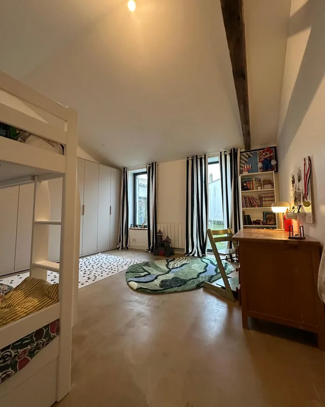 Chambre d’enfant lumineuse avec lit superposé, armoires blanches et bureau